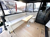 Cockpit seating with teak, opening patio style doors to saloon